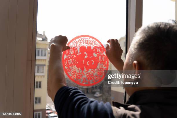 senior chinese man with chinese new year paper-cut - provinz shandong stock-fotos und bilder