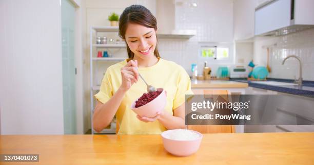 woman eats black rice - black rice imagens e fotografias de stock