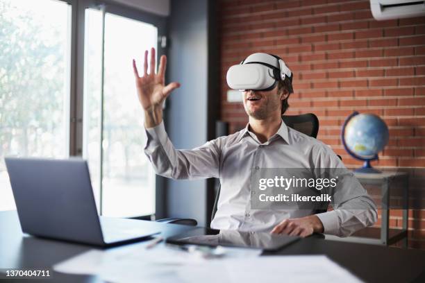 businessman wearing vr headset running a business meeting at home - electronic form stock pictures, royalty-free photos & images