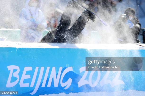 Rong Ge of Team China falls over the safety barrier after their run during the Women's Snowboard Big Air Qualification on Day 10 of the Beijing 2022...