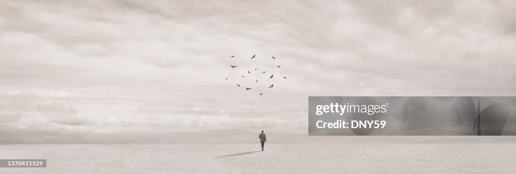 Circle Of Ravens Gathering Over Businessman On Long Walk in The Desrt