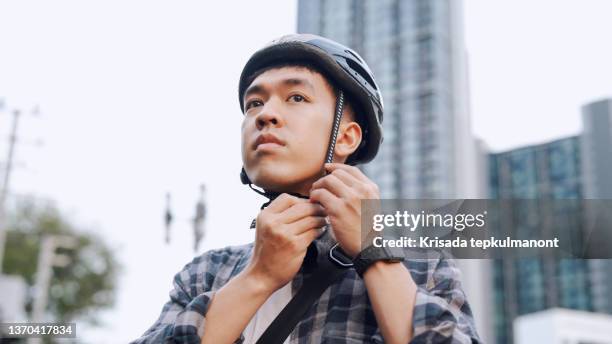 delivery man wearing a crash helmet. - southeast asian ethnicity stock pictures, royalty-free photos & images