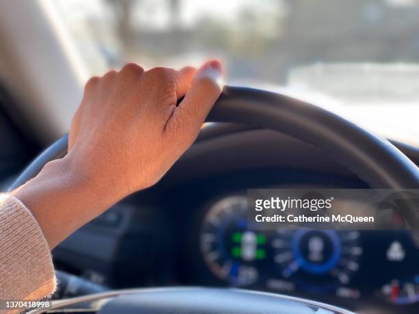 black stay-at-home mother waits in daily carpool line to pick up child from school - hand steering wheel stock pictures, royalty-free photos & images