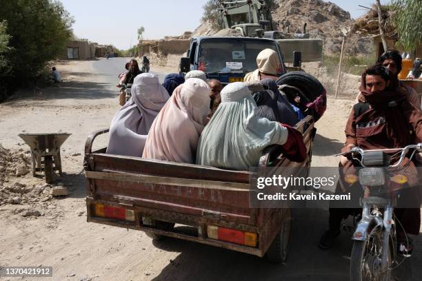 Pashtun women in Burkas sit on the back of a mini-van on September 23, 2021 in Panjwai, Afghanistan.