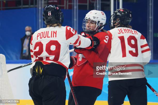 Sarah Forster of Team Switzerland gets shoved by Marie-Philip Poulin of Team Canada in the second period during the Women's Ice Hockey Playoff...