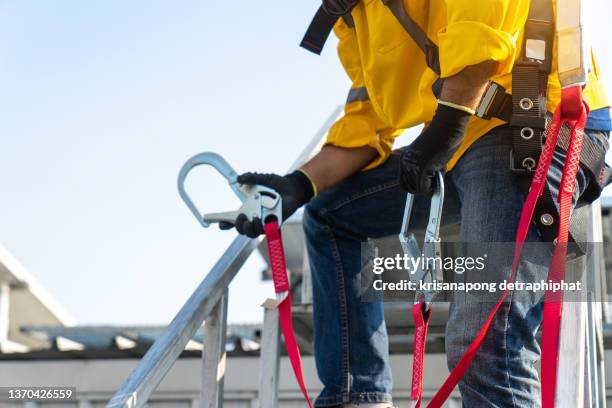 worker wearing safety harness and safety line working - safety harness - fotografias e filmes do acervo