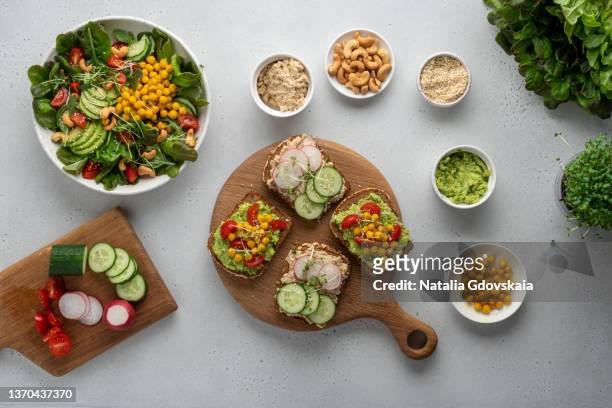 making vegan toasts for lunch with healthy plant-based salad. preparing delicious flexatarian food - chick pea salad stock pictures, royalty-free photos & images