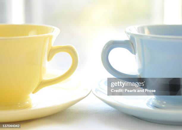 vintage blue and yellow teacups and saucers - dinge die zusammenpassen stock-fotos und bilder