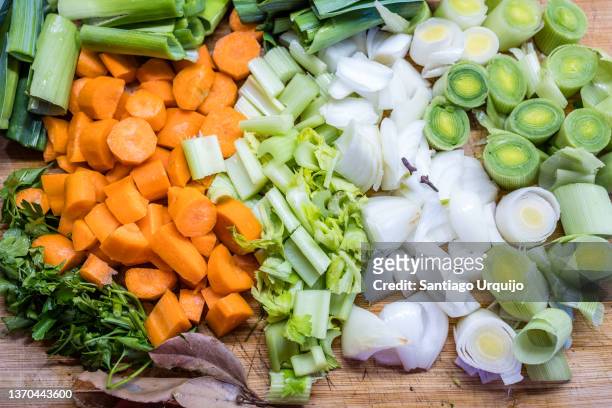 close-up of chopped vegetables on a wooden cutting board - tagliato a pezzi foto e immagini stock