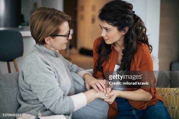 young woman and her mother having serious conversation - mature women talking stock pictures, royalty-free photos & images