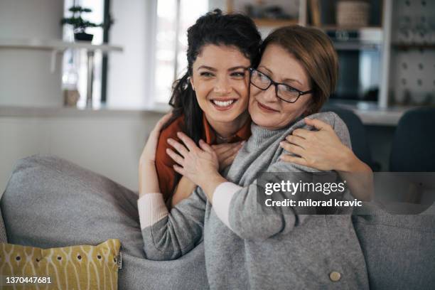 smiling young woman hugging her mother from behind - surprised mum stock pictures, royalty-free photos & images