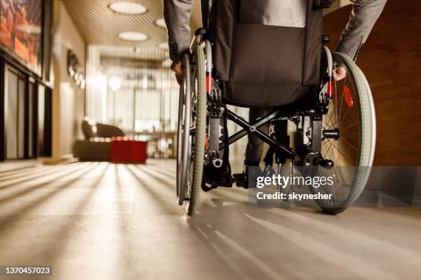 rear view of unrecognizable businessman in a wheelchair. - orthopaedic equipment stock pictures, royalty-free photos & images