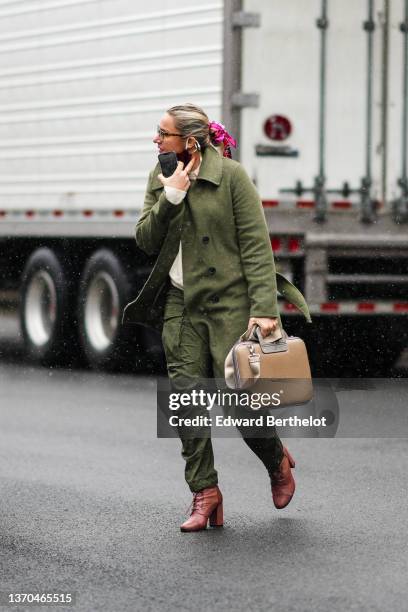 Guest wears glasses, a white and pink print pattern silk scarf as an elastic hair, a white latte wool pullover, a khaki long wool coat, rings, khaki...