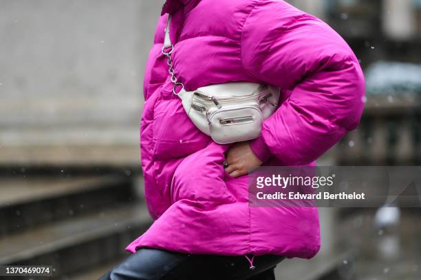 Guest wears a pink shiny oversized high neck puffer jacket, black shiny leather large pants, a white leather fanny pack bag, outside Ulla Johnson,...