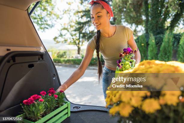 asian woman buying flowers at garden center - yellow boot stock pictures, royalty-free photos & images