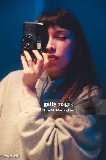 若い女性はアナログ写真の自分撮りミラーを取ります - アナログ ストックフォトと画像