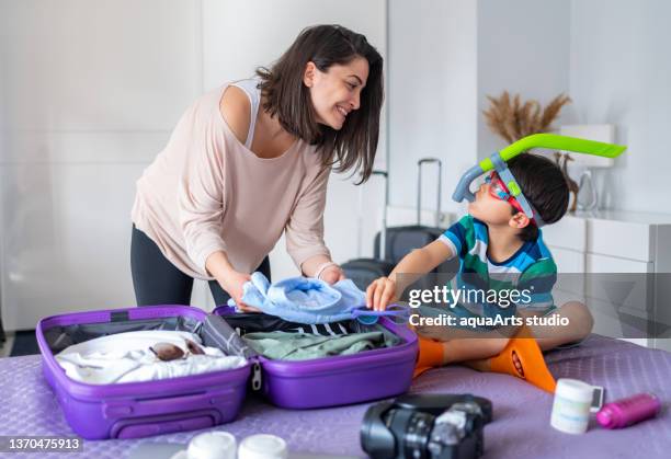 packing for holiday - suitcase packing stockfoto's en -beelden