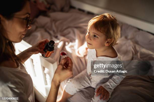 mother taking care of sick child - syrup stock pictures, royalty-free photos & images