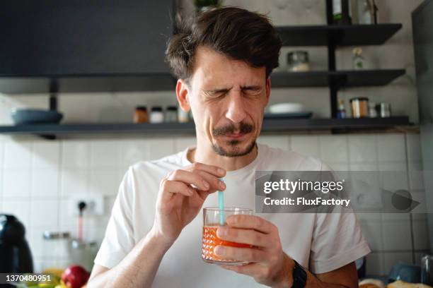 man making the face after he tasted the juice - tart bildbanksfoton och bilder