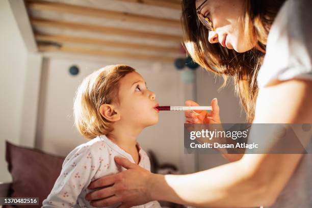 mother taking care of sick child - syrup stock pictures, royalty-free photos & images