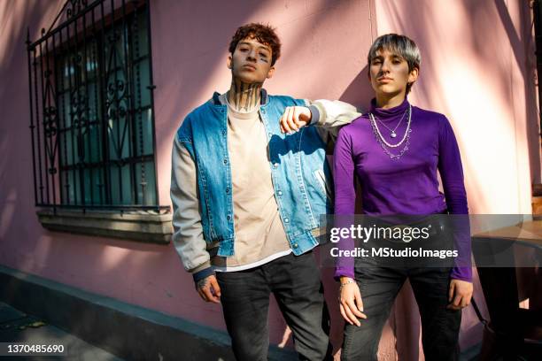 two young people are standing on the corner of the street - lilac fashin bildbanksfoton och bilder