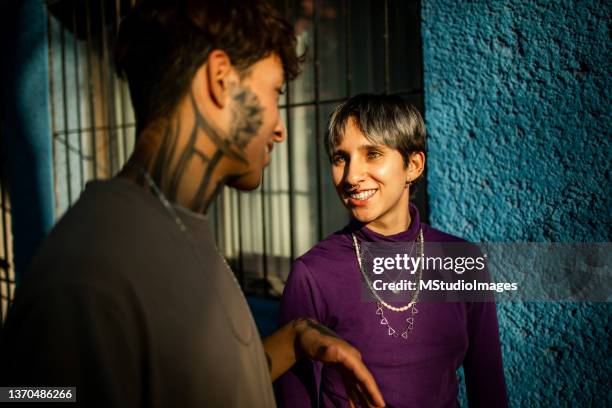 two friends walking down the street and talking - androgynous stock pictures, royalty-free photos & images
