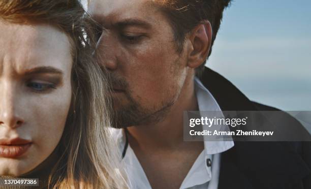 worried and introspective couple against the sky - holiday glamour stock pictures, royalty-free photos & images