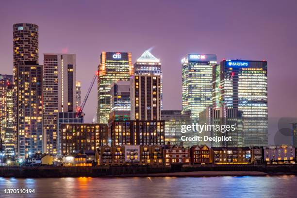 financial district of canary wharf, london bei nacht, beleuchtete gebäude - barclays markenname stock-fotos und bilder