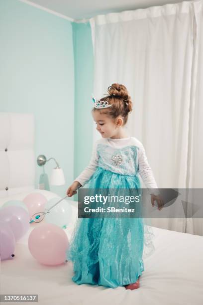 little girl dressed as a princess playing with balloons on the bed - princess bedroom stock pictures, royalty-free photos & images