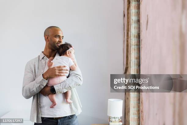 happy new dad walks with baby in home - young family with baby stock pictures, royalty-free photos & images