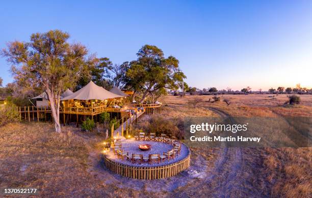 aerial view of the luxury tented bar lounge and dining area with fire pit at tuludi safari camp,botswana - africa safari stock pictures, royalty-free photos & images