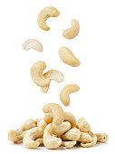 Cashew nuts are falling on a pile on a white background. Isolated