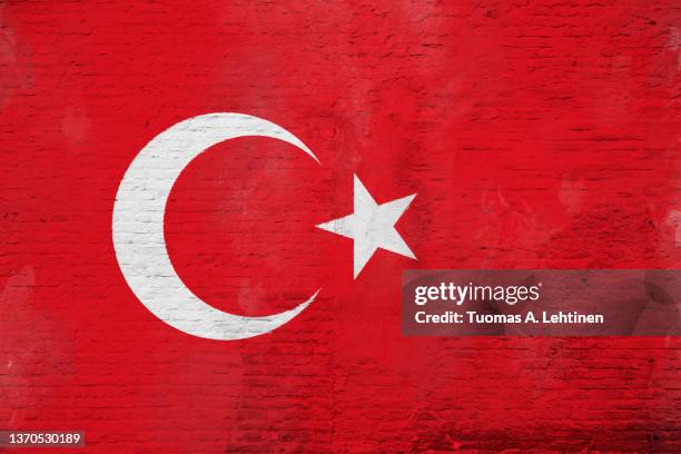 full frame photo of a weathered flag of turkey painted on a plastered brick wall. - bandera turca fotografías e imágenes de stock