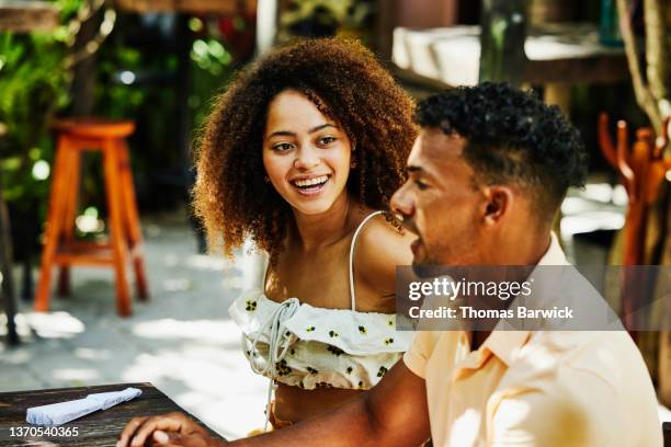 medium shot of smiling woman having lunch with boyfriend at outdoor cafe - al fresco dining stock pictures, royalty-free photos & images