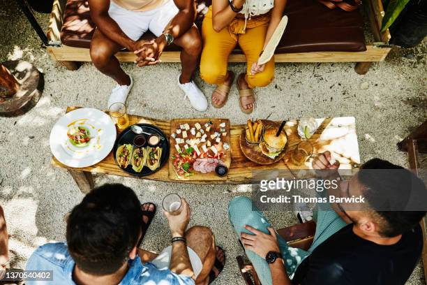 wide shot overhead view of friends sharing food at outdoor restaurant - coppie cibo food bistrot foto e immagini stock