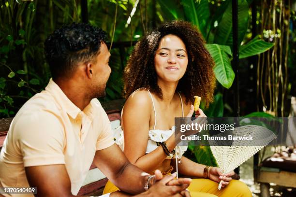 medium shot of smiling woman sharing lunch with boyfriend at outdoor restaurant - coppie cibo food bistrot foto e immagini stock