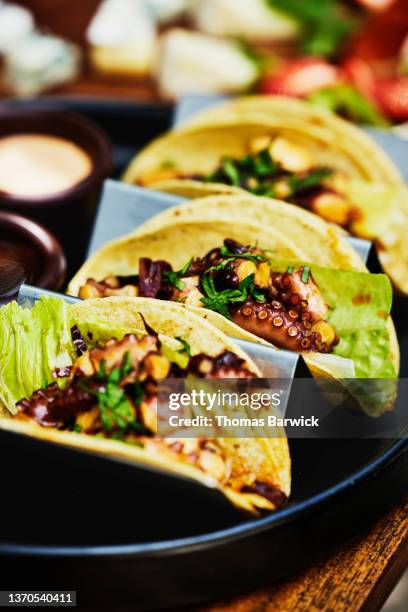 medium close up shot of octopus tacos on table at outdoor restaurant - food abundance stock pictures, royalty-free photos & images