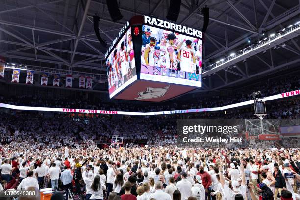 Fans of the Arkansas Razorbacks storm the court after a overtime win against the Auburn Tigers at Bud Walton Arena on February 08, 2022 in...