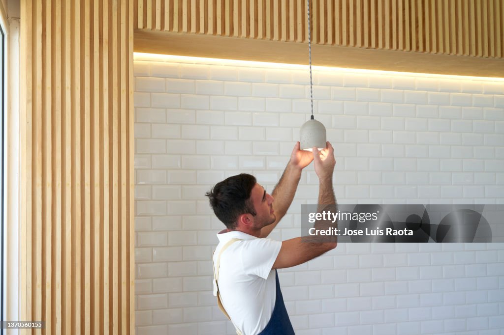 Working on electricity. Man Changing Lights.