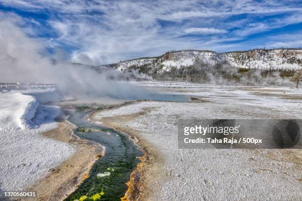 scenic view of hot spring against cloudy sky - wyoming stock pictures, royalty-free photos & images