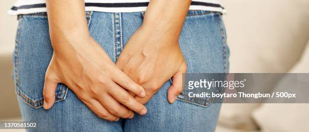 people woman hand holding her bottom - woman hemorrhoids stock pictures, royalty-free photos & images