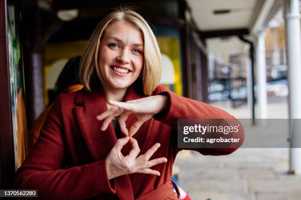 hermosa mujer usando el lenguaje de señas - tecnología de asistencia fotografías e imágenes de stock