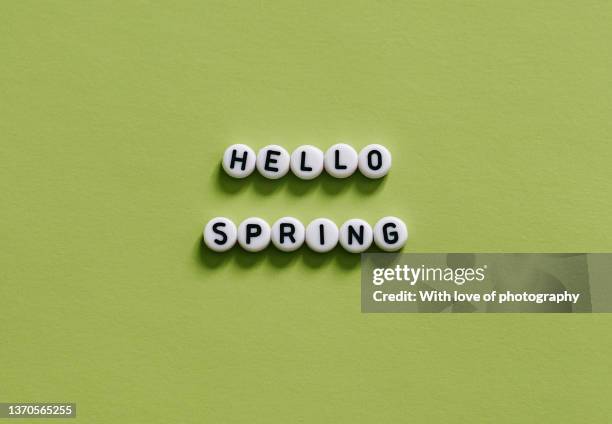 hello spring text message on light green background lettering - welcome text stock pictures, royalty-free photos & images