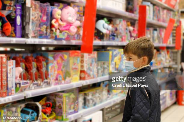 boy at toy store - loja de brinquedos imagens e fotografias de stock