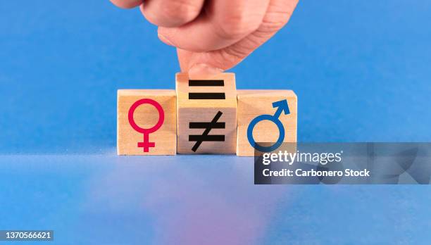 concept of gender equality. a hand changes an unequal sign to an equal sign between male and female symbols. - segno di uguale foto e immagini stock