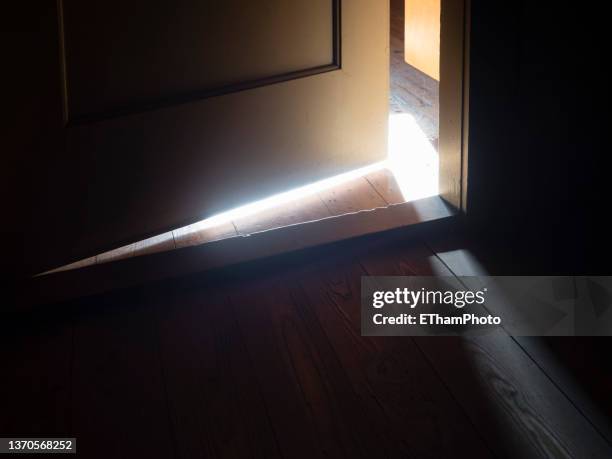 bright sunlight coming through crack of ajar door to dark attic - attic storage stock pictures, royalty-free photos & images