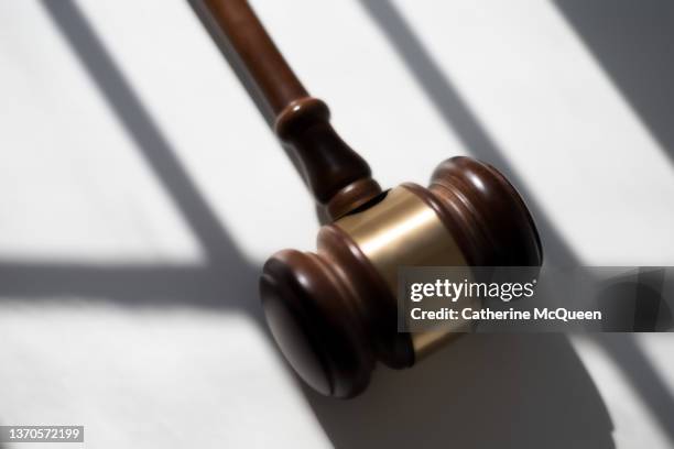 judge’s traditional wooden gavel on white background & shadow detail - lawsuit stock-fotos und bilder