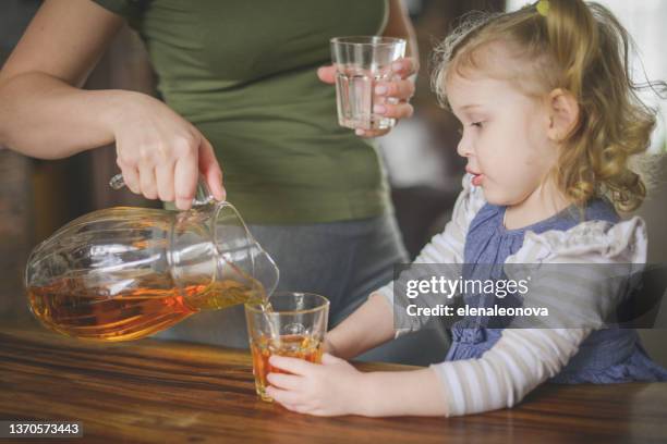 baby girl blonde in home interior , drinking apple juice - apple juice stock pictures, royalty-free photos & images