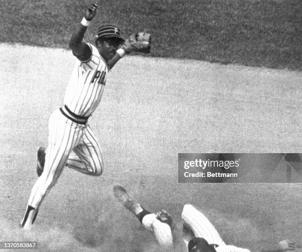 Pittsburgh second baseman Rennie Stennett jumps out of the way of New York's Mike Vail after making a double play throw to first during 8th inning of...