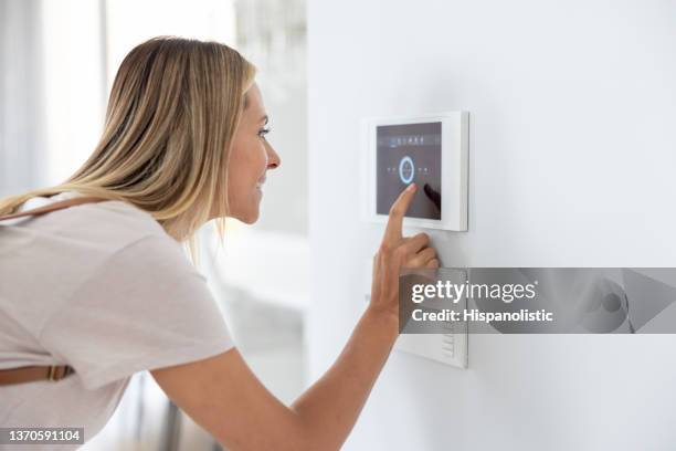 woman leaving her smart house and setting the alarm - alarm system stock pictures, royalty-free photos & images